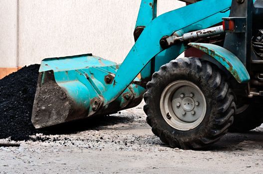 The wheel bulldozer works at asphalt laying.