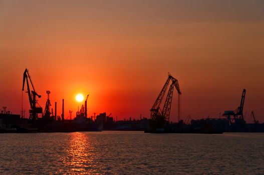 Evening sea port, cargo cranes against the setting sun. Odessa. Ukraine.