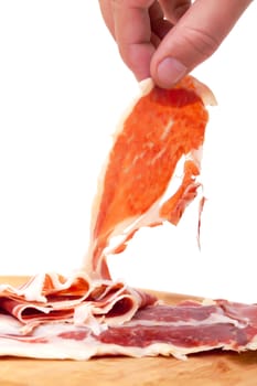 Thinly Sliced ​​Spanish Jamon with a Hand, on a white background