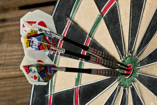 A close-up cropped image of the dart board with a bulls eye pin at the center 