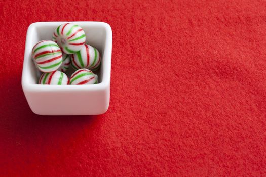 A peppermint bowl of candy isolated on red 