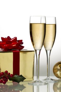 View of two glass of white wine with gift box and other Christmas ornaments.