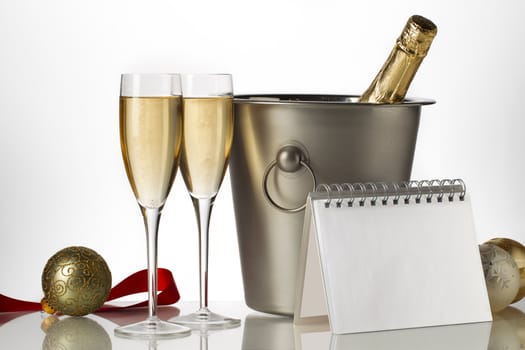 Champagne bottle in ice bucket with flutes and Christmas baubles