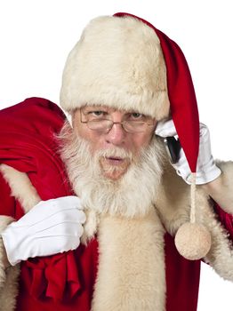 A close up portrait of Santa while holding a cellular phone and a sack of gift looking straight at the camera 