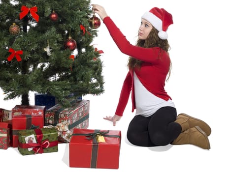 Image of a blonde lady putting a ball decoration in the Christmas tree