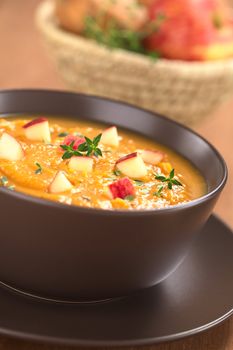 Bowl of fresh homemade sweet potato and apple soup with thyme (Selective Focus, Focus in the middle of the soup)