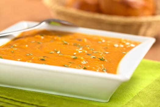 Bowl of fresh homemade sweet potato soup with thyme (Selective Focus, Focus one third into the soup)