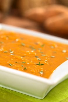 Bowl of fresh homemade sweet potato soup with thyme (Selective Focus, Focus one third into the soup)