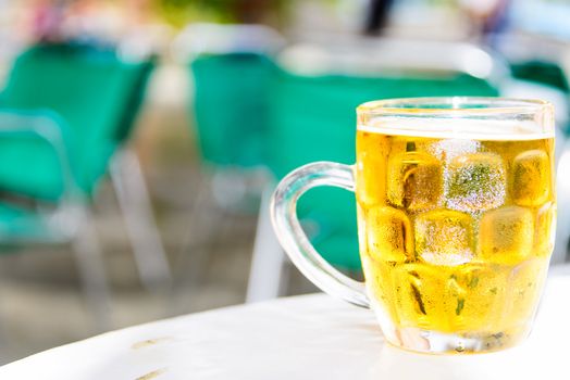 Glass of cold beer on table of street cafe
