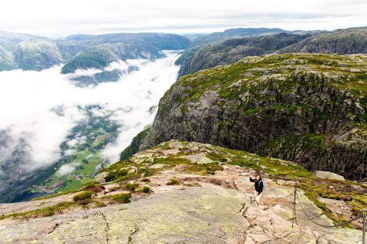 Young woman on a mountain with view of Lysefjord and Lysebotn