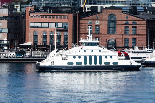 Ferry in a bay with cityscape in the background