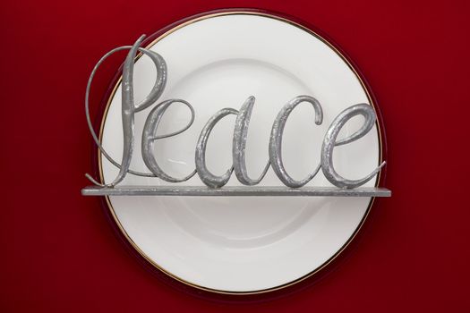 Image of white plate with word peace red background