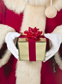Santa in a red costume while holding a gift 