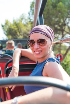 Smiling woman in sunglasses and bandana on bus