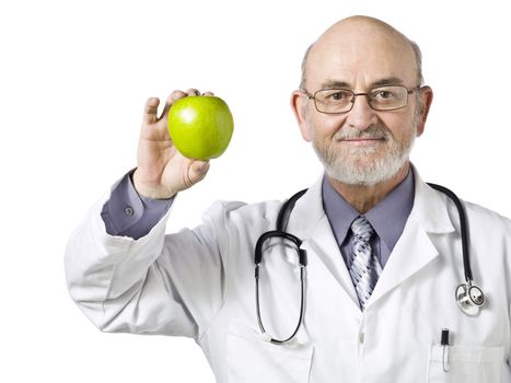 A male doctor holding a green apple and smiling on a white background