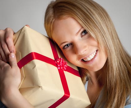 Happy beautiful young woman holding gift box