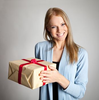 Happy beautiful young woman holding gift box