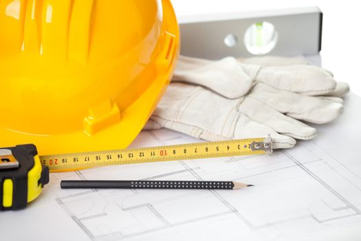 Hardhat gloves and measuring instruments on blueprint