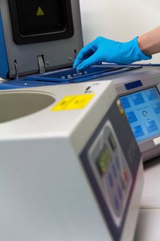 Research scientist putting test tube into real-time pcr machine