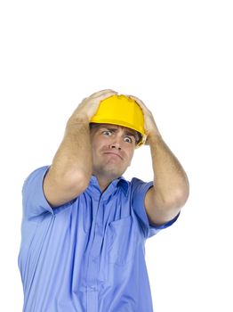 A man wearing a yellow hard hat holding his head