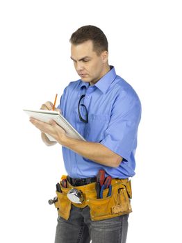 A young male construction worker writing on the notebook isolated on a white background 