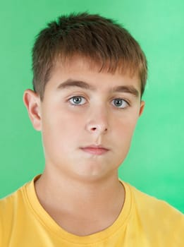 studio portrait of young boy on green background