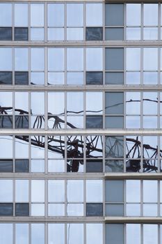 Reflection of crane in a transparent glass wall of building