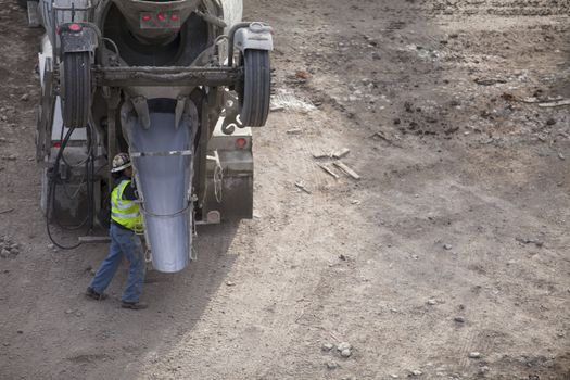 Cropped image of cement mixer truck and a worker in a construction site