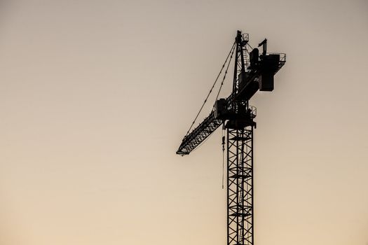 Image of a hoisting crane in a noon time sky background