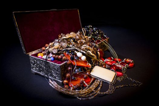 Silver treasure box in the dark, full of necklaces and jewelery