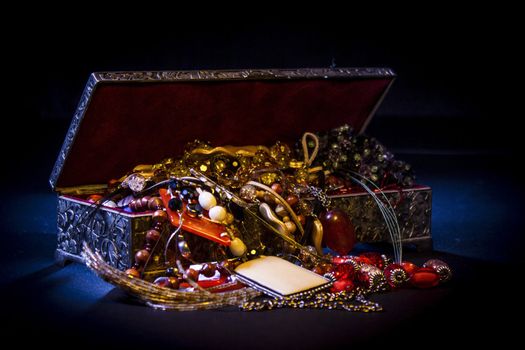 Silver treasure box in the dark, full of necklaces and jewelery