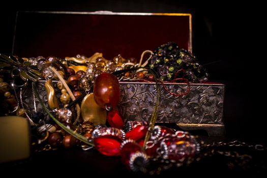 Silver treasure box in the dark, full of necklaces and jewelery