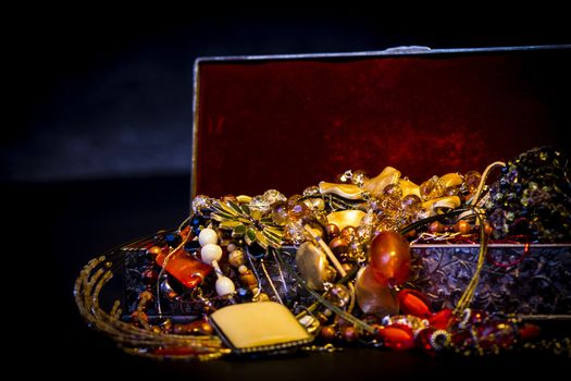 Silver treasure box in the dark, full of necklaces and jewelery