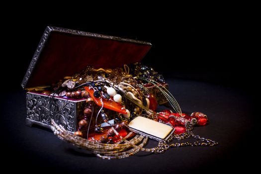 Silver treasure box in the dark, full of necklaces and jewelery