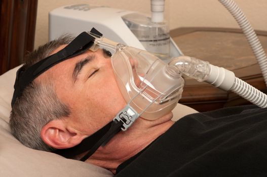 Man with sleeping apnea and CPAP machine