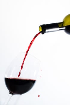 Red wine pouring into a glass with bright background