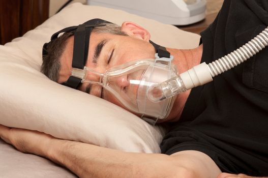 Man with sleeping apnea and CPAP machine