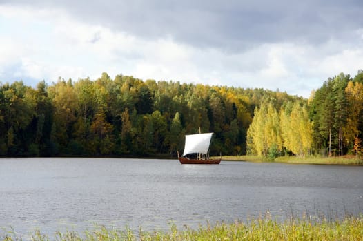 Sailing boat on a background of a forest 