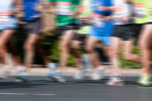 Group of marathon racers running with heavy motion blur applied