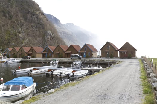 small harbor with mountains and houses in background - norway, europe