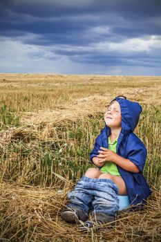 child is sitting in a field on the pot