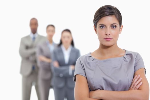 Close-up of a serious business team crossing their arms and standing behind each other with focus on the foreground woman