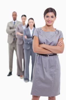 Business team crossing their arms and standing behind each other with focus on the foreground woman who is smiling