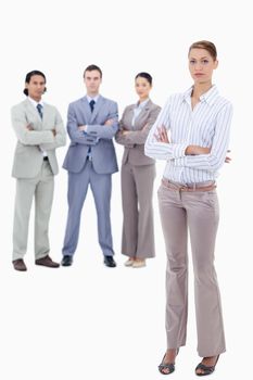 Secretary crossing her arms with serious business people behind her against white background