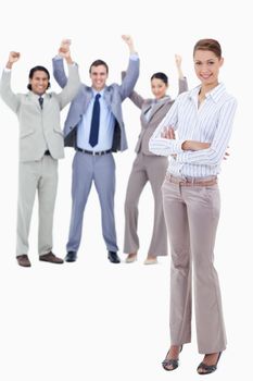 Secretary smiling and crossing her arms with very enthusiastic business people behind her against white background