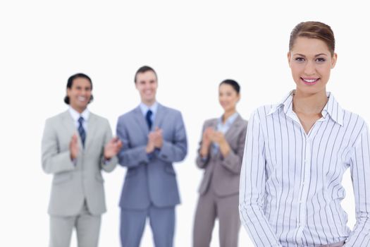 Close-up of a woman smiling with business people applauding in background