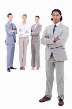 Businessman crossing his arms with serious people in background against white background