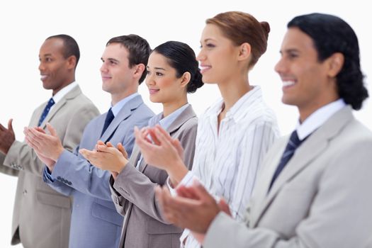 Close-up of a business team smiling and applauding with focus on the last three people against white background