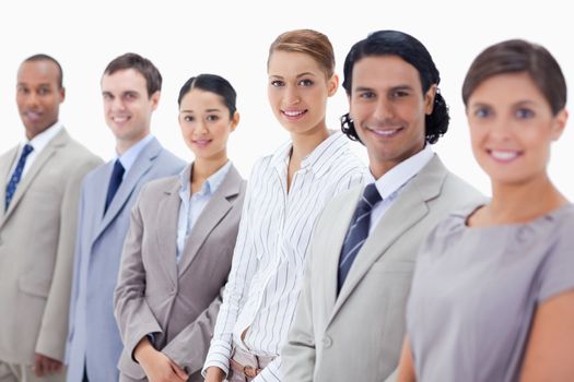 Close-up of smiling business people looking straight with focus on the two women in the middle 