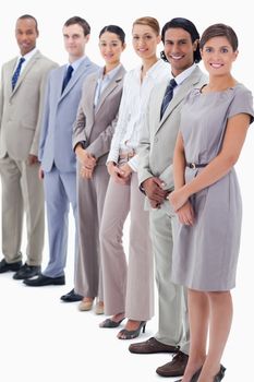 Colleagues smiling looking straight with focus on the first man against white background